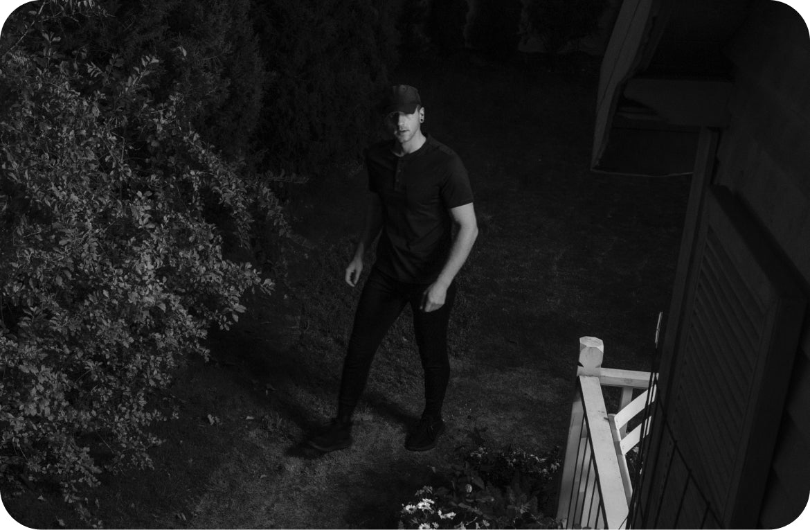 Mann geht nachts im Garten mit eufy am Haus