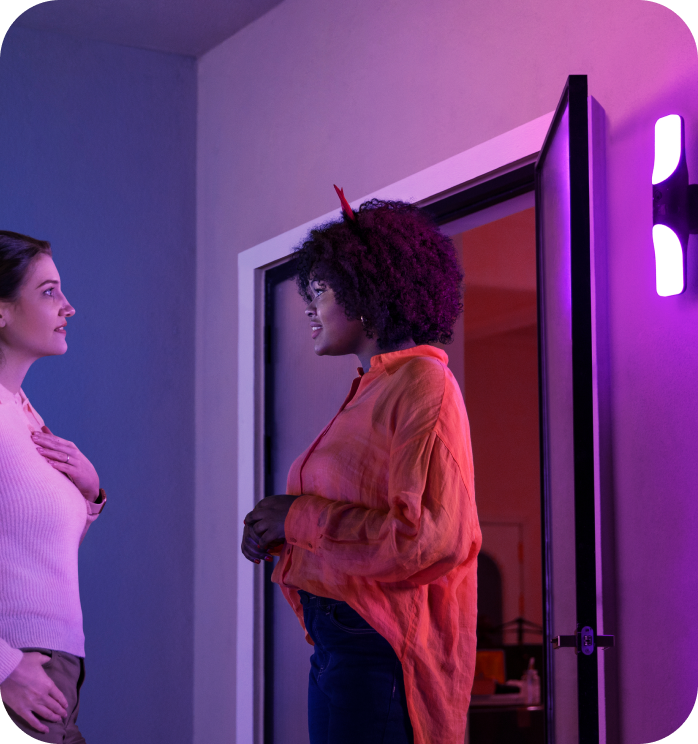 eufy mit lila Leuchte und zwei Frauen am offenen Türrahmen